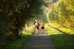 Adults running down a path