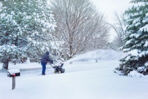 Wintertime person using snow blower