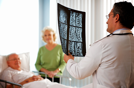 Senior couple discussing X-ray with doctor.